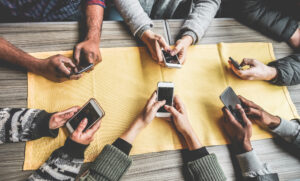 people sitting at a table holding their phones