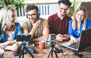 young professionals working together at a laptop while drinking coffee