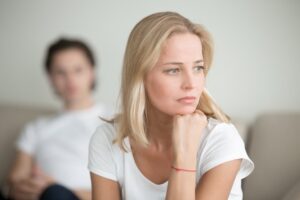 serious sad woman thinking over a problem man sitting aside