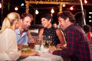 group of friends eating dinner at rooftop restaurant