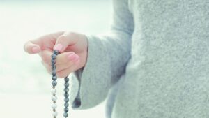 woman lit hand close up counts malas strands of gems